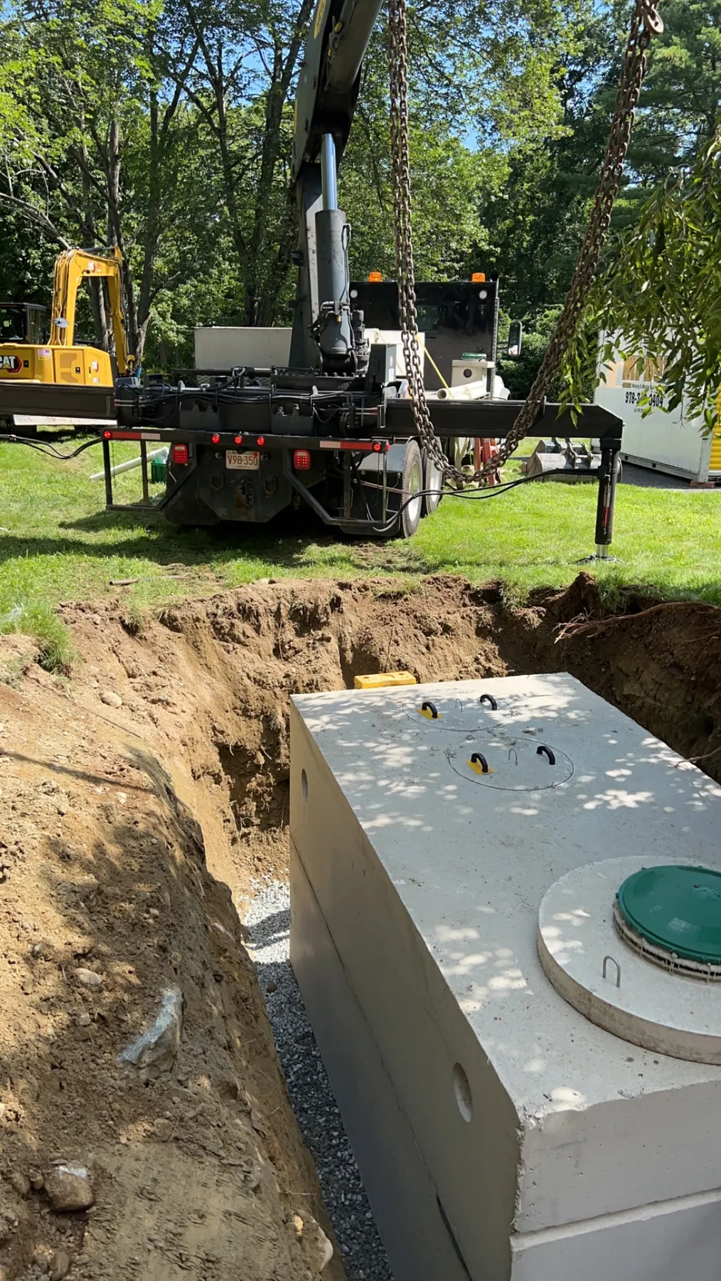Concrete septic tank set into the excavation by boom truck, Belchertown MA